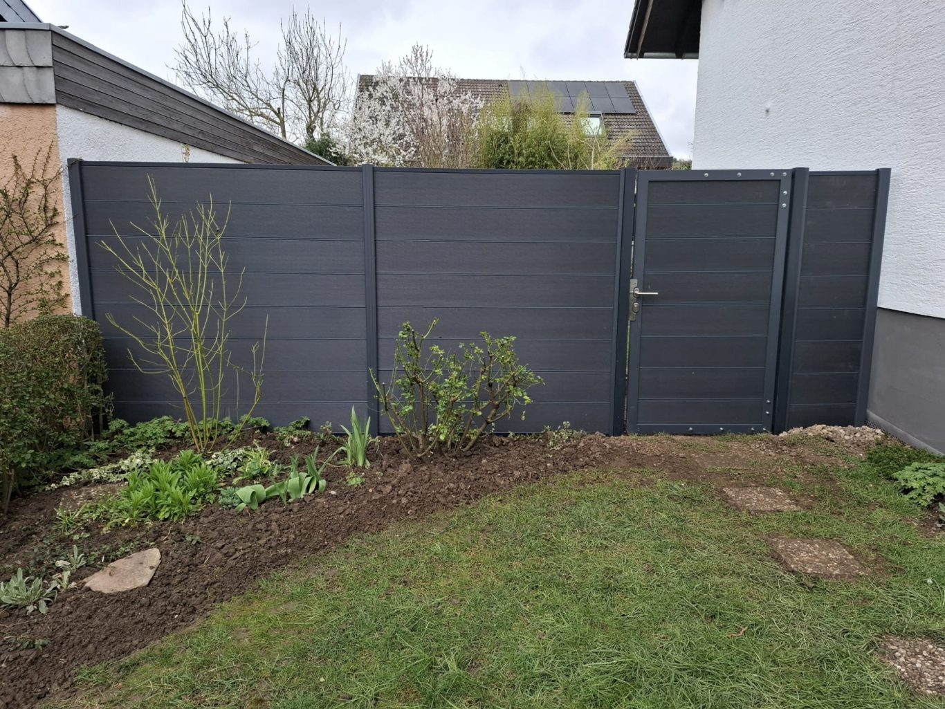 Sichtschutz und Gartentor in Anthrazit Anthrazitfarbener Sichtschutzzaun mit passendem Gartentor zwischen Haus und Garage