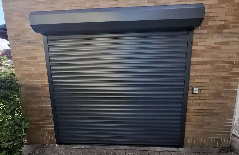 Anthrazitfarbenes Rolltor an einer Garage mit Ziegelfassade