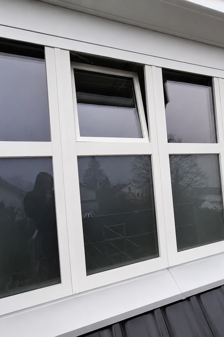 Weiße Fensterfront mit einem gekippten Fensterflügel